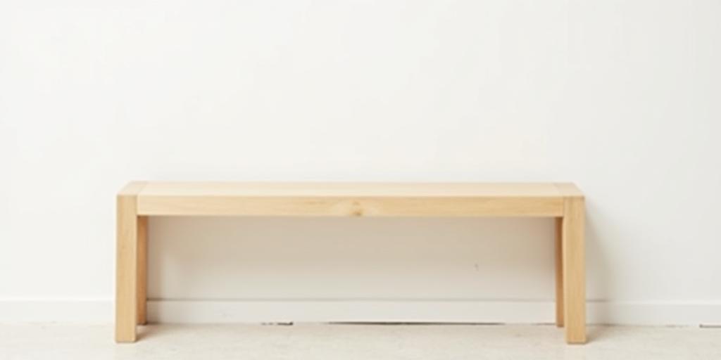 A simple and elegant solid ash wood bench against a light wall.